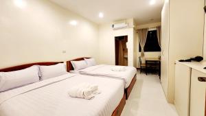 um quarto de hotel com duas camas com toalhas em Chotika Hotel โรงแรมโชติกา ณ เชียงคาน em Chiang Khan