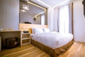 ein Schlafzimmer mit einem großen Bett und einem großen Spiegel in der Unterkunft CHECK inn Express Taichung FuXing Hall 2 in Taichung