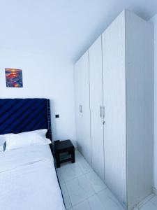 KiambuOne bed airbnb with pool by Omuts的卧室配有白色橱柜和大床 更多8张照片