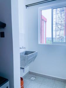 KiambuOne bed airbnb with pool by Omuts的带水槽和窗户的浴室