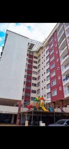 KiambuOne bed airbnb with pool by Omuts的一座大型公寓楼,前面设有一个游乐场