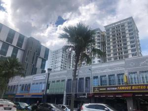 a palm tree in front of a building with tall buildings at Reen's Cosy Place in Cyberjaya