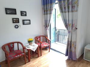 een eetkamer met een tafel en stoelen en een raam bij GREEN TOWN hotel HỘI AN in Hội An