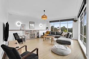Una sala de estar con un sofá y una chimenea. en The Family Beachside Escape by Ready Set Stay - HOUSE, en Rosebud 20 fotos más