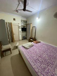 - une chambre avec un lit violet et un chien dans l'établissement A Family Home TT Nagar Bhopal, à Bhopal