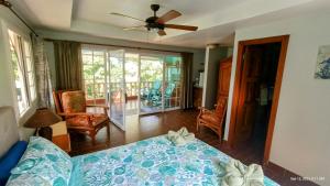 um quarto com uma cama e uma ventoinha de tecto em Villas at Gone Fishing Panamá Resort em Boca Chica