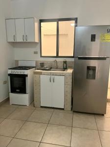 eine Küche mit weißen Schränken und einem Kühlschrank in der Unterkunft Apartamentos Trebol in Comayagua