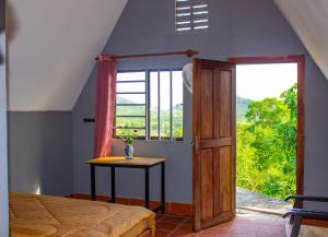 a bedroom with a bed and a table and a window at Sabay Farm in Kampot