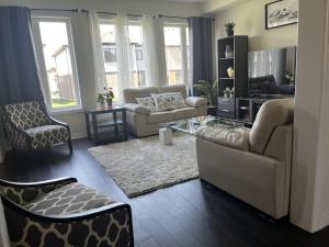 a living room with a couch and a table and chairs at Spacious,comfy house,less than 15 mins to Niagara Falls in Thorold