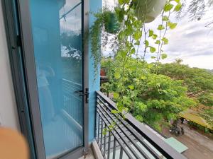een balkon met een glazen deur en uitzicht op een tuin bij GREEN TOWN hotel HỘI AN in Hội An