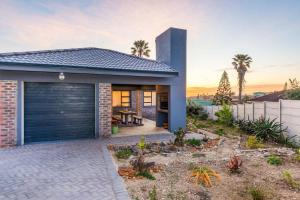 ein Backsteinhaus mit Garage in der Unterkunft Gasteria Cottage in Mossel Bay
