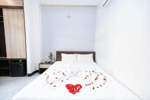 a bed with a bow tie and roses on it at Ciao Quy Nhơn in Quy Nhon