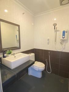 ein Badezimmer mit einem Waschbecken, einem WC und einem Spiegel in der Unterkunft Alia Express Sendayan in Kampong Baharu Jimah