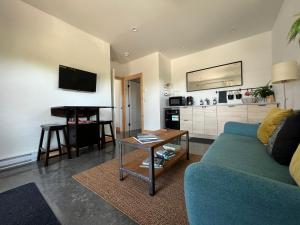a living room with a blue couch and a table at Slack tide suite in Ucluelet