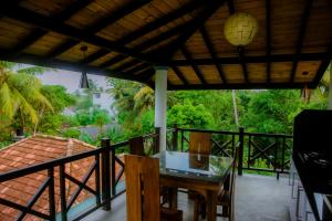 Un patio con una mesa y sillas en un balcón. en Kadolana Villa, en Mirissa