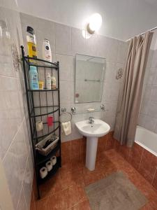 ein Bad mit einem Waschbecken und einem Spiegel in der Unterkunft Cozy Paphos Apartment in Paphos City