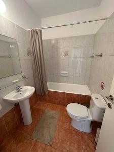 ein Badezimmer mit einem WC, einem Waschbecken und einer Badewanne in der Unterkunft Cozy Paphos Apartment in Paphos City