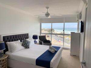 a bedroom with a bed with a teddy bear on it at Hi Surf Beachfront Resort Apartments in Gold Coast