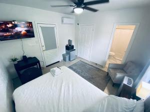 a bedroom with a white bed and a ceiling fan at Holistic Gem w/1Gig Wi-Fi & free parking in Houston