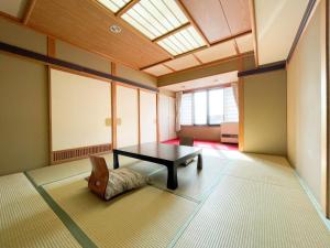 a room with a table and a chair in it at Masuya Ryokan in Nozawa Onsen +30 photos