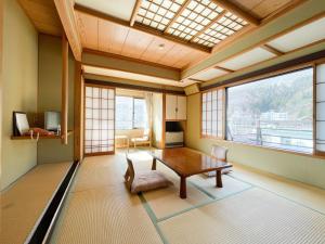 a living room with a table and a window at Masuya Ryokan in Nozawa Onsen