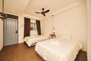 1 dormitorio con 2 camas y ventilador de techo en Hotel Gray in Boracay en Boracay