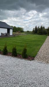 dom z dużym polem zielonej trawy w obiekcie Przytulny domek z ogrodem, parkingiem oraz innymi udogodnieniami w mieście Malbork