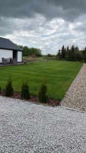 uma casa com um grande campo de relva verde em Przytulny domek z ogrodem, parkingiem oraz innymi udogodnieniami em Malbork