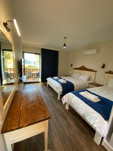 a hotel room with two beds and a table at Ekin Pansiyon in Kaleucagız