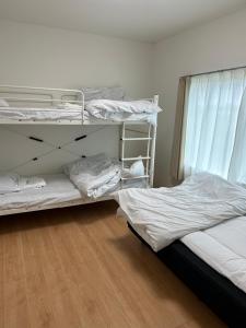 Postel nebo postele na pokoji v ubytování 東神楽大学ゲストハウス