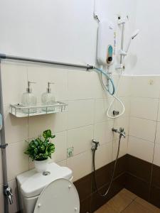 a bathroom with a shower with a toilet and a plant at 3BR MINIMALIST Homestay NEAR KKIA Cyber City in Kapayan