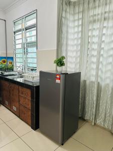 a kitchen with a plant on top of a refrigerator at 3BR MINIMALIST Homestay NEAR KKIA Cyber City in Kapayan