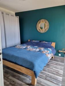 Dormitorio azul con cama con espejo en la pared en Sainte Cécile: appartement 2ch 6/7 pers, en Camiers