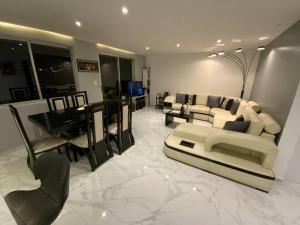 ein Wohnzimmer mit einem Sofa und einem Esszimmer in der Unterkunft Bonito apartamento remodelado en excelente sector in Cuenca