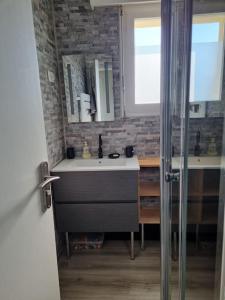 een badkamer met een wastafel en een glazen douche bij Sainte Cécile: appartement 2ch 6/7 pers in Camiers