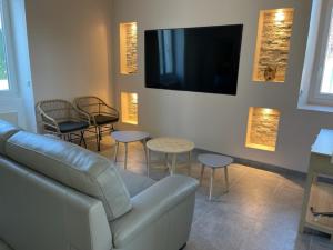 uma sala de estar com um sofá e cadeiras e uma televisão em MAISON VENEUX LES SABLONS-FONTAINEBLEAU-MORET SUR LOING em Veneux-les-Sablons