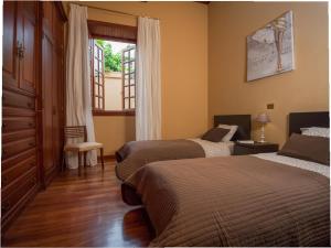 a bedroom with two beds and a window at Residencial Los Oliva Confort in Gáldar