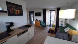 a kitchen and a living room with a couch and a table at moderne barrierefreie Wohnung auf dem Land bei Neuruppin in Lichtenberg