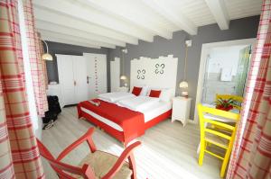 a bedroom with a red and white bed and chairs at Horse House in Romallo