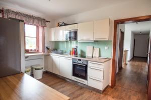 a kitchen with white cabinets and a stove top oven at Apartmány Chajdovka in Boží Dar