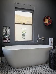 a white bath tub in a bathroom with a window at Pineapple House Boutique Hotel in Cape Town