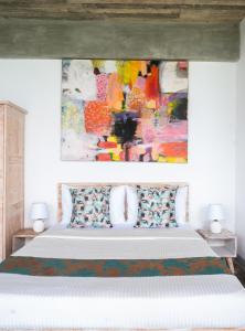 a bedroom with a bed with a painting above it at The Southern Gate in Ahangama