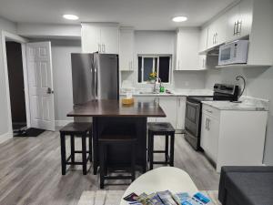 uma cozinha com um frigorífico, uma mesa e cadeiras em New 2 bedroom suite near surrey centre em Surrey