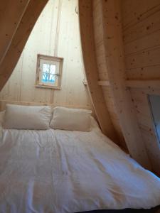 uma cama num chalé de madeira com uma janela em Adorable chalet em Pouligney
