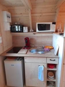 a small kitchen with a sink and a microwave at Adorable chalet in Pouligney