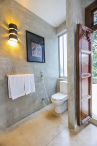 y baño con aseo y toallero. en Margossa Residence by 55TG, en Kandy