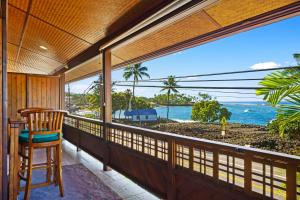 einen Balkon mit einem Stuhl und Meerblick in der Unterkunft Seahorse Luxury Suite at Seaspray Oceanview in Kailua-Kona
