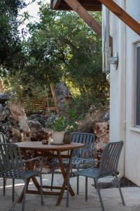 einen Holztisch und Stühle auf einer Terrasse in der Unterkunft בית האלה Home of Ela in Abirim