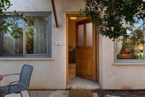 a door to a house with a table and a chair at בית האלה Home of Ela in Abirim