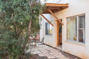 un patio con mesa y sillas junto a una casa en בית האלה Home of Ela, en Abirim